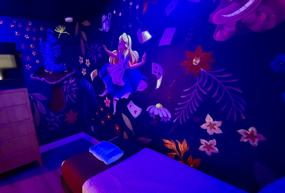 Alice in Wonderland mural glowing under UV light