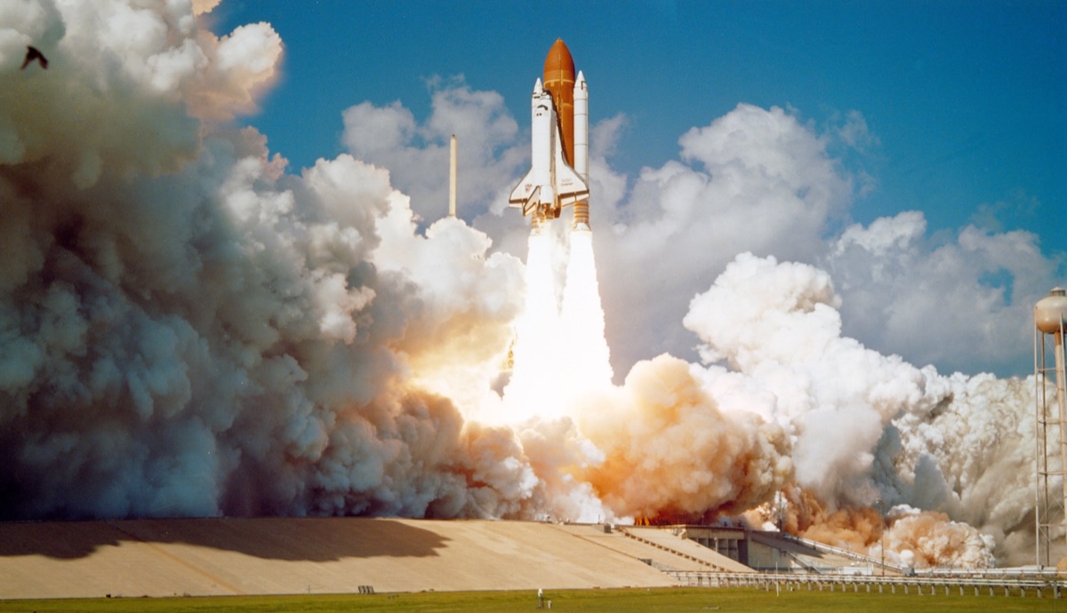 Space Shuttle launching from Kennedy Space Center with billowing exhaust clouds