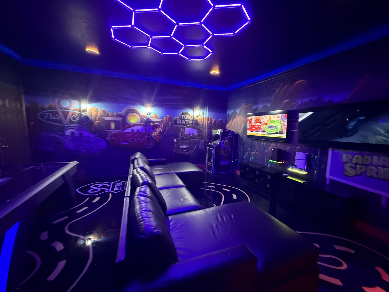 Radiator Springs game room glowing under blacklight with LED hexagon ceiling and Route 66 floor at Time-Out Corner, Lakeside