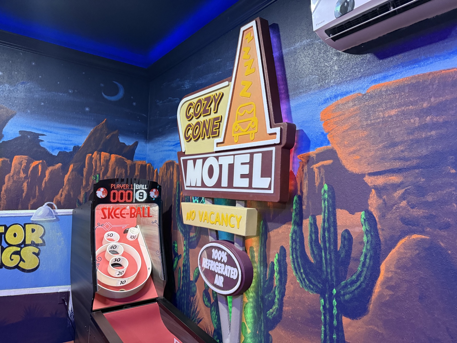 Cozy Cone Motel sign and skee-ball in the Radiator Springs game room