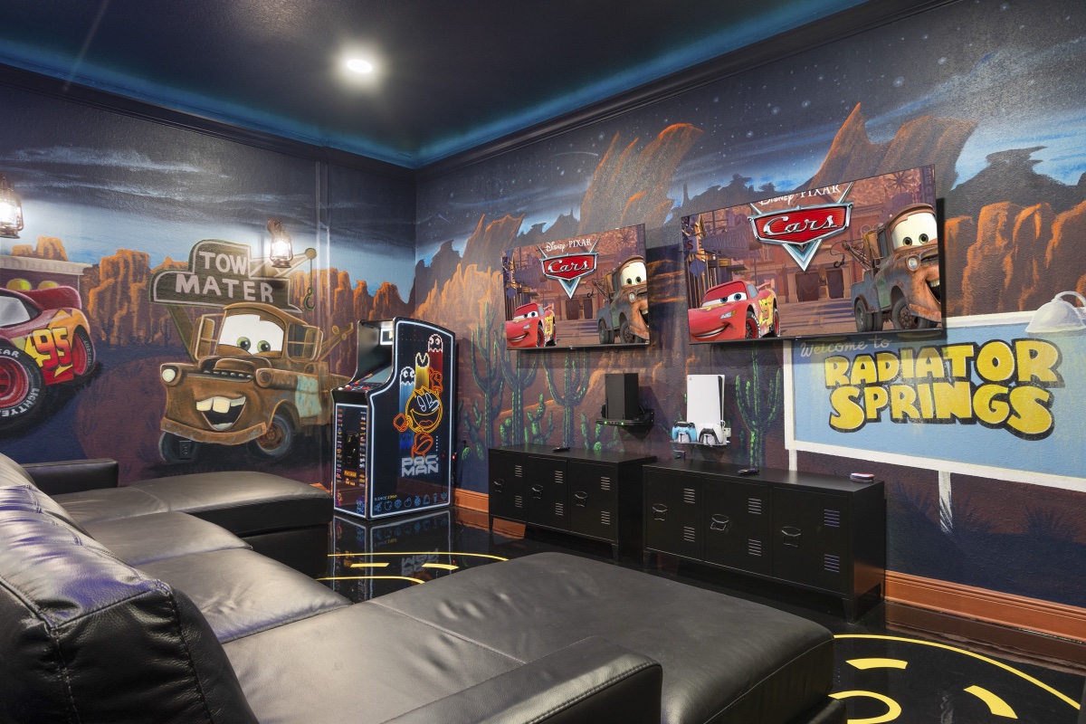 Tow Mater mural, Pac-Man arcade, and gaming consoles in the Radiator Springs game room