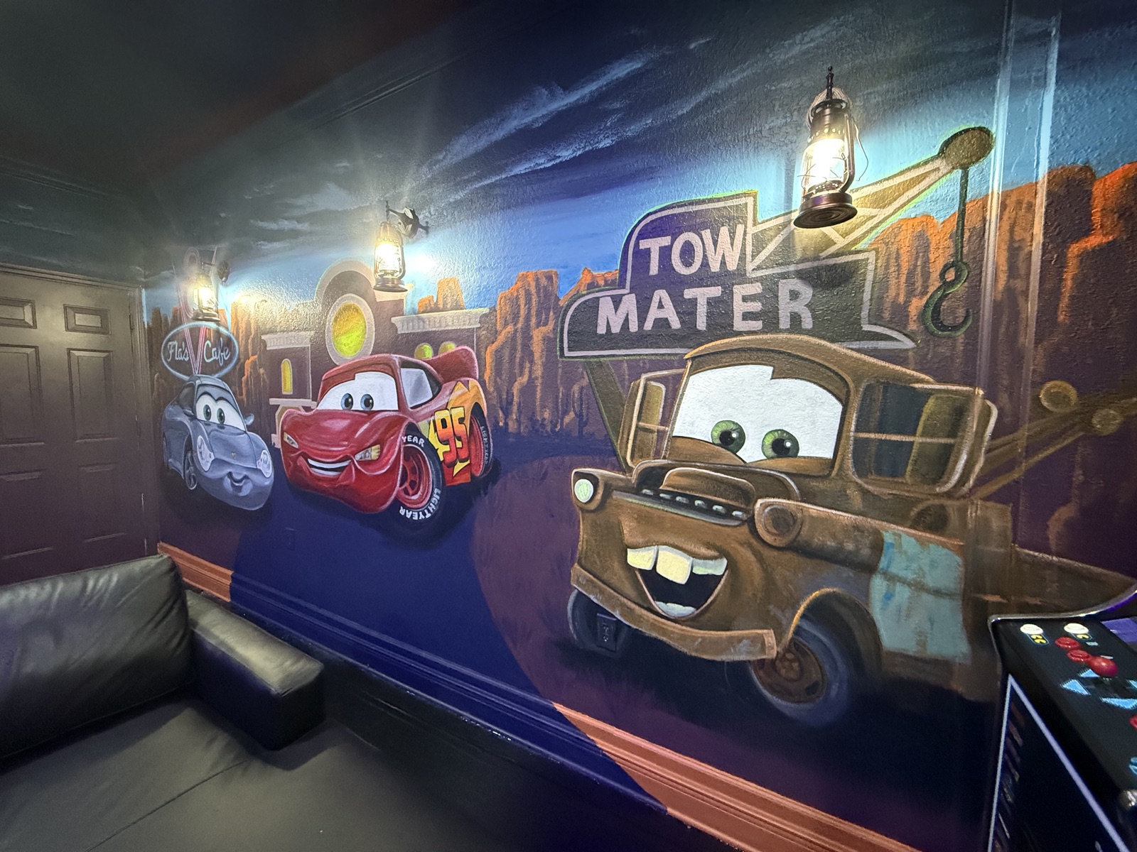 Hand-painted Lightning McQueen and Tow Mater mural in the Radiator Springs game room